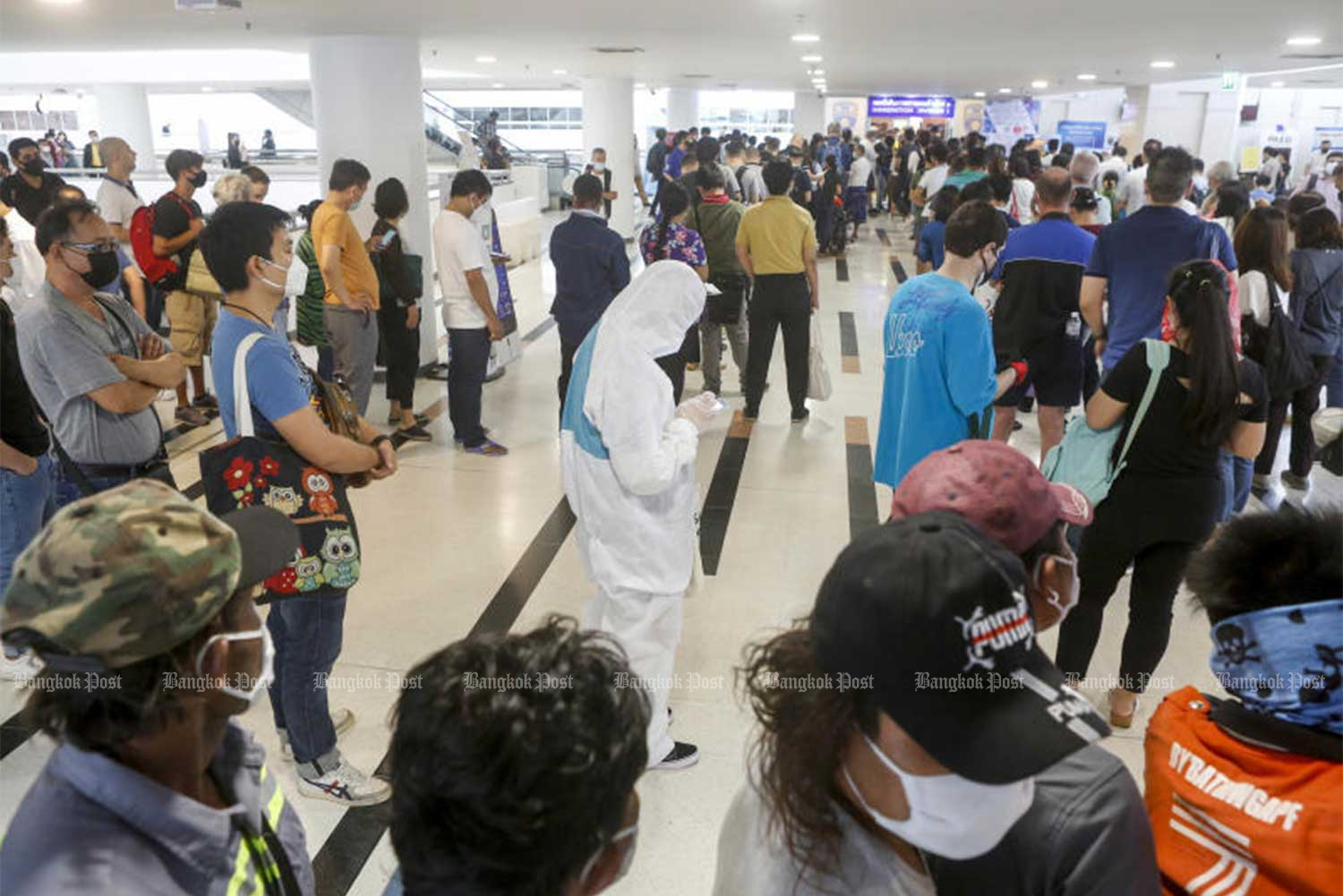 Long queues of foreign nationals at the Immigration Bureau office at the Government Complex in Nonthaburi on March 23, seeking visa extensions after the Covid-19 pandemic disrupted their travel plans. The bureau later declared a “visa amnesty” until July 31 to reduce the risk of crowding at its offices. (File photo by Pattarapong Chatpattarasill)