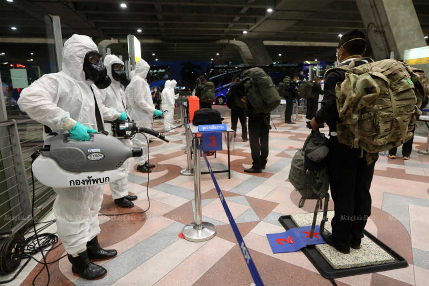 Disease control officials greet the 151 Thai solders returning from a military exercise in Hawaii, at Suvarnabhumi airport on July 22. (Photo: Wichan Charoenkiatpakul)