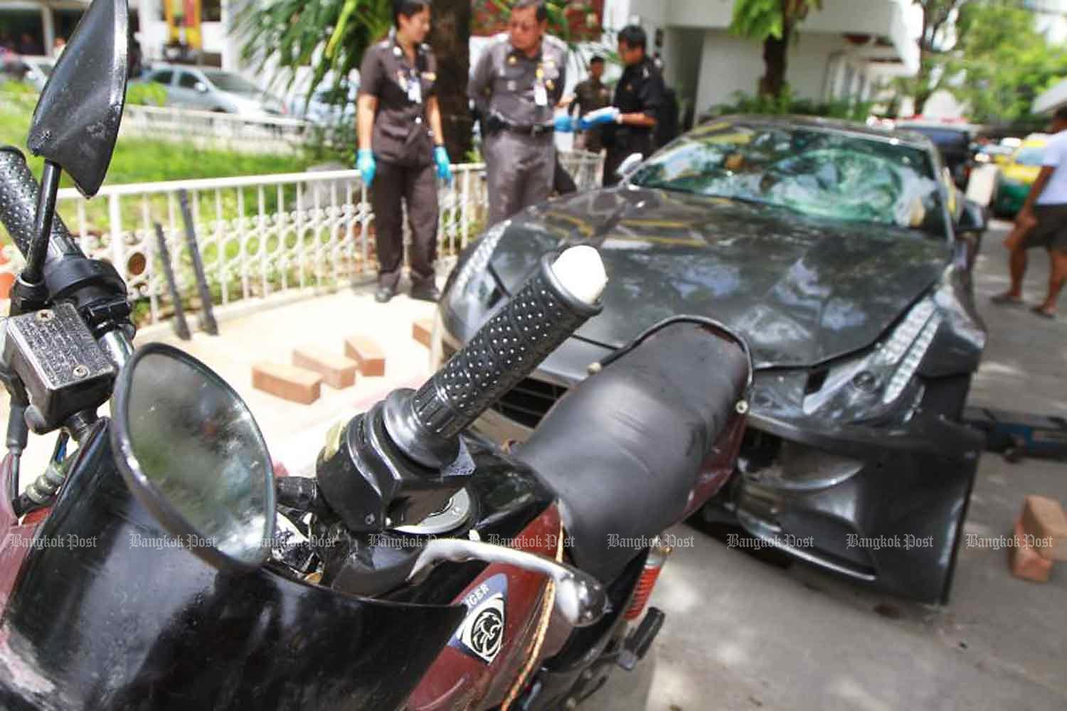 Forensic police inspect a motorcycle belonging to Pol Snr Sgt Maj Wichian Klanprasert of Thong Lor police station and a Ferrari driven by Vorayuth Yoovidhya, the youngest son of Red Bull executive Chalerm Yoovidhya, following the accident in September 2012. (Photo by Somchai Poomlard)