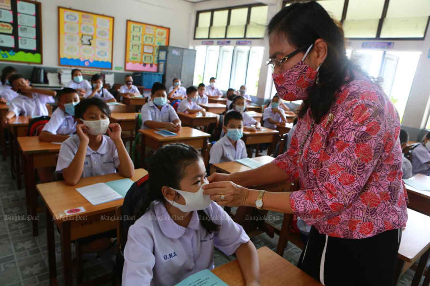 Students are advised on how to wear face masks properly when full-scale school teaching resumes at Intarumphun School in Samut Prakan province on Thursday. Meanwhile, the government reported three new Covid-19 cases among returnees from India and Singapore. (Photo by Somchai Poomlard) Students are advised on how to wear face masks properly when full-scale school teaching resumes at Intarumphun School in Samut Prakan province on Thursday. Meanwhile, the government reported three new Covid-19 cases among returnees from India and Singapore. (Photo by Somchai Poomlard)