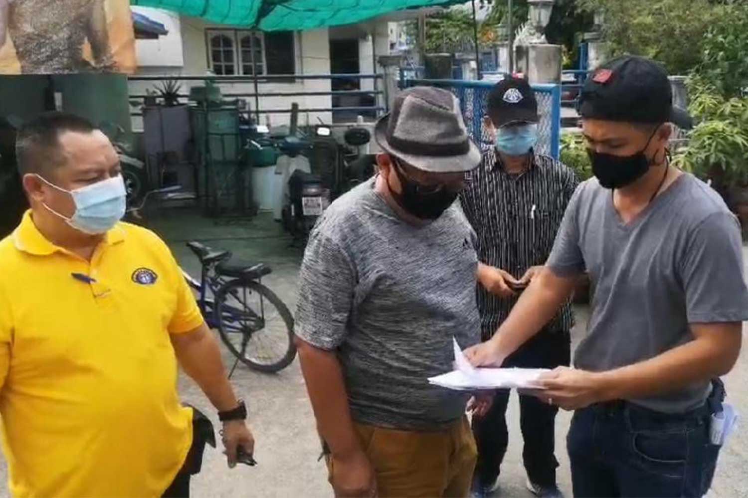 Plainclothes police show an arrest warrant to a 56-year-old man (centre) before taking him into custody in Pak Kret district of Nonthaburi on Friday. (Photo: Crime Suppression Division) Plainclothes police show an arrest warrant to a 56-year-old man (centre) before taking him into custody in Pak Kret district of Nonthaburi on Friday. (Photo: Crime Suppression Division)