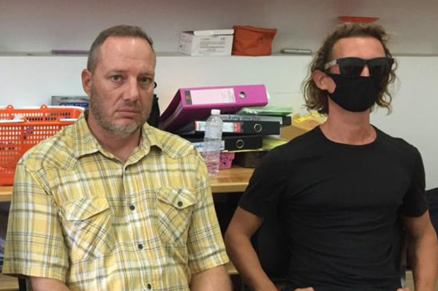 Attila Ott (left) and Francesco Simonetti report to police on Koh Phangan on Tuesday on charges of intruding in an area designated for environmental protection. (Photo: Supapong Chaolan)