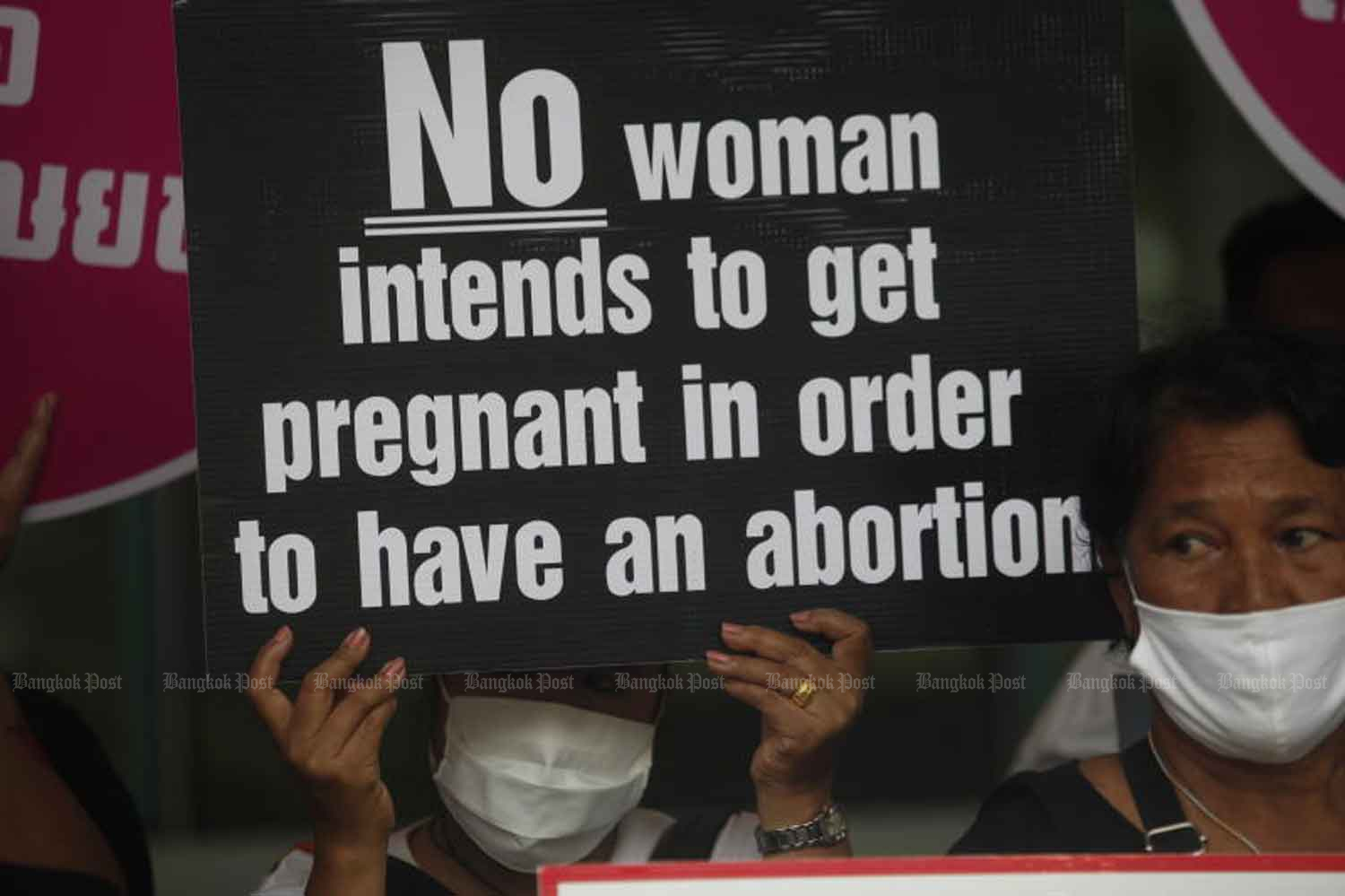 An activist raises a sign during a rally at the Council of State to demand that Section 301 of the Criminal Code be revoked to allow women to have an abortion without being subject to legal punishments. (Photo by Nutthawat Wicheanbut)