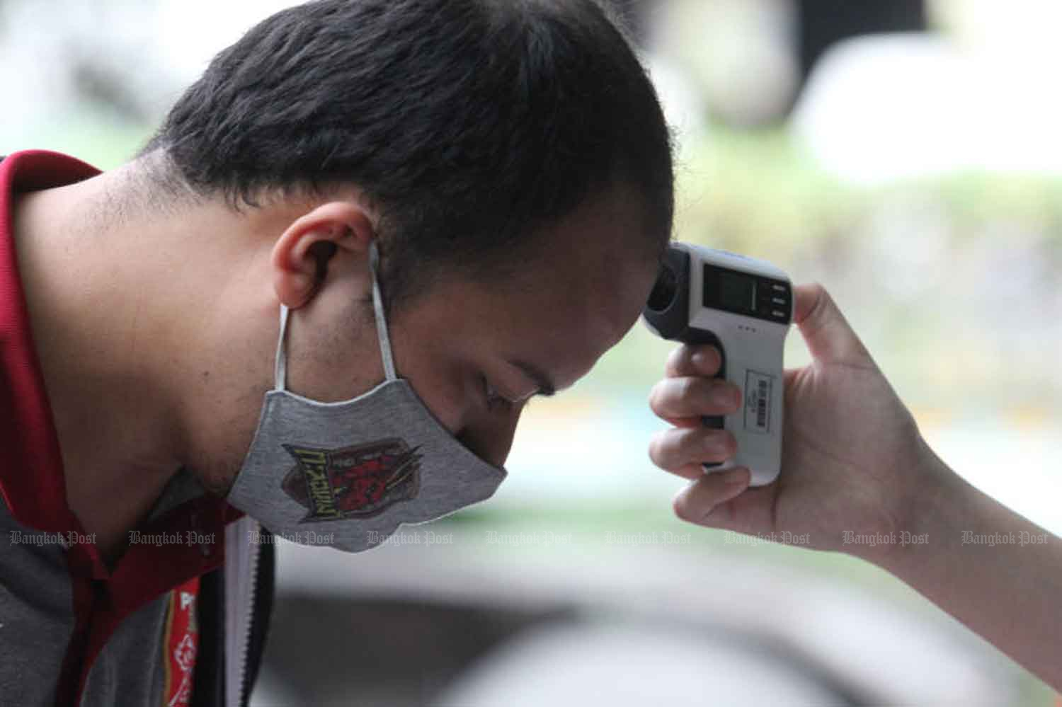A football fan has his temperature checked before being allowed into PAT Stadium in Klong Toey district, Bangkok, to watch a Thai League football match on Sunday. WICHAN CHAROENKIATPAKUL A football fan has his temperature checked before being allowed into PAT Stadium in Klong Toey district, Bangkok, to watch a Thai League football match on Sunday. WICHAN CHAROENKIATPAKUL
