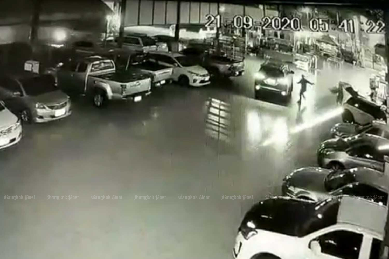 The killer is seen running to a car after shooting a woman who had just given alms to a monk, in the car park of Wat Nimmanruedee in Bangkok shortly before dawn on Monday. (Capture from video clip posted on rescue volunteer Chonyuen Wisutthipat Facebook page)