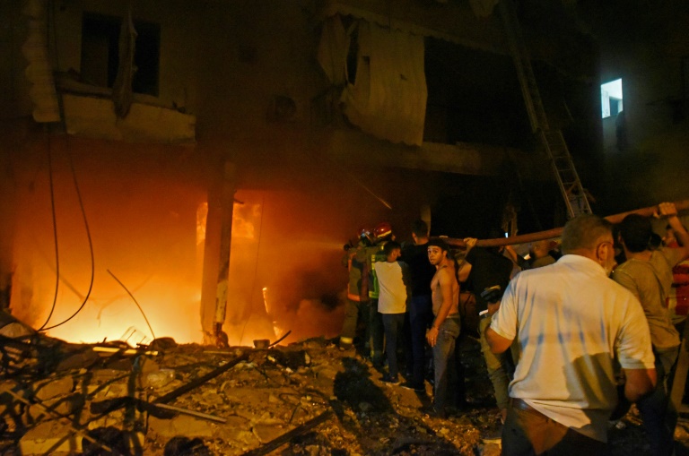 Firefighters extinguish a fire at a building after a fuel tank exploded in Beirut's Tariq al-Jdide neighbourhood Firefighters extinguish a fire at a building after a fuel tank exploded in Beirut's Tariq al-Jdide neighbourhood