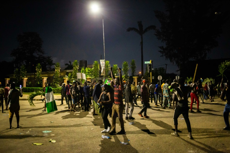 Witnesses said armed gunmen opened fire on a crowd of over 1,000 people to disperse them after a curfew was imposed to end spiralling protests over police brutality. Witnesses said armed gunmen opened fire on a crowd of over 1,000 people to disperse them after a curfew was imposed to end spiralling protests over police brutality.