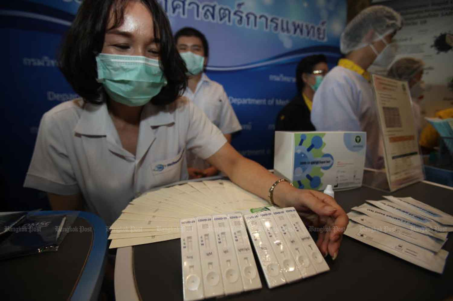 A public health official shows Covid-19 test kits developed by the Public Health Ministry. They are among items on display at the exhibition 'Smart Living with Covid-19' hosted by the ministry at Pullman King Power Hotel, Bangkok and at the heart of plans to gradually reopen the country. (Photo by Nutthawat Wicheanbut)