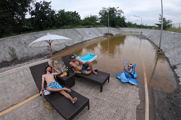 Jitiwat Nakchamsilp (left) lies on a lounge chair with a man and a girl in a flooded underpass in Non Sung district of Nakhon Ratchasima. (Photo from Jetiya Nakchamsilp Facebook account)