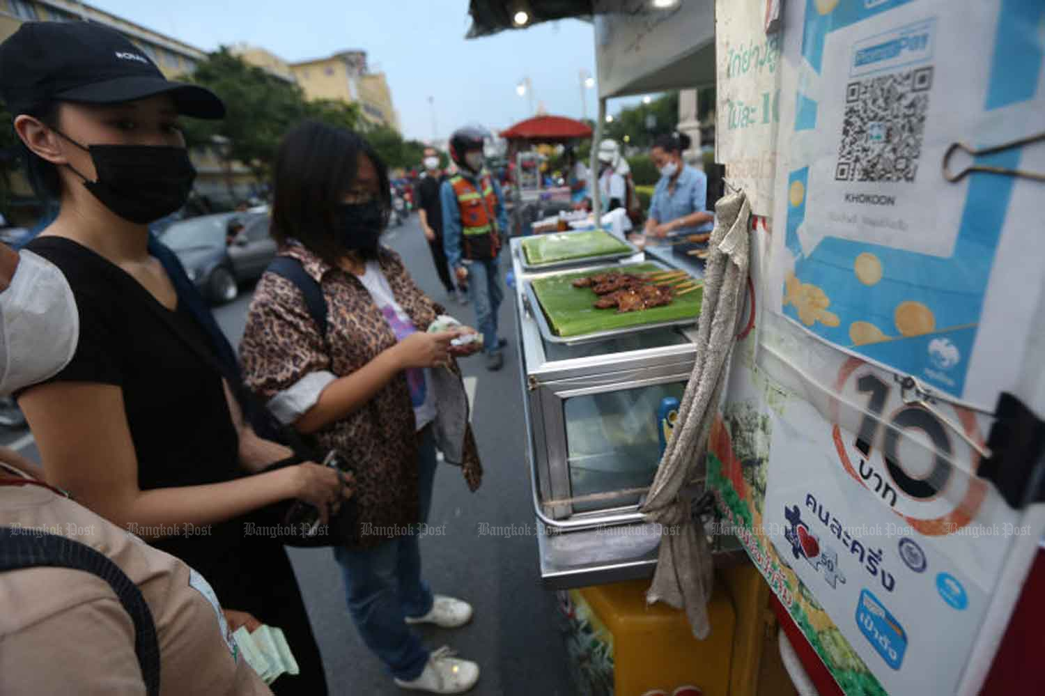 Consumers are at the stall of a food vendor who participates in the government's co-payment scheme aimed at economic stimulation, in Bangkok this month. (Photo by Varuth Hirunyatheb) Consumers are at the stall of a food vendor who participates in the government's co-payment scheme aimed at economic stimulation, in Bangkok this month. (Photo by Varuth Hirunyatheb)
