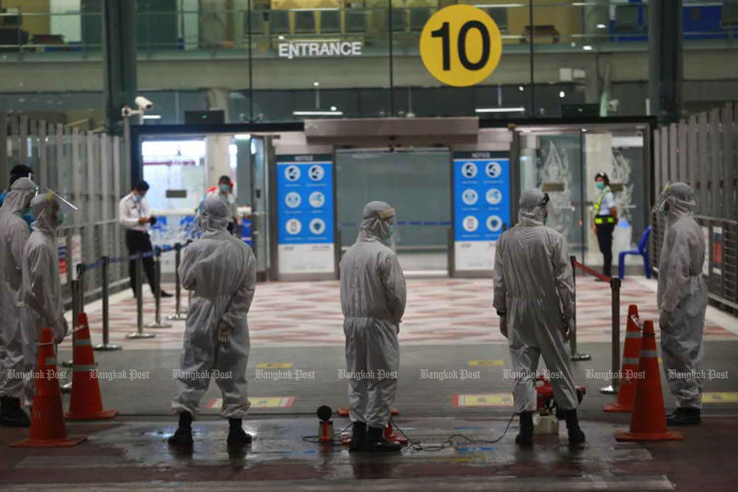 Disease control officials wait for arrivals at Suvarnabhumi airport. (Photo: Somchai Poomlard)