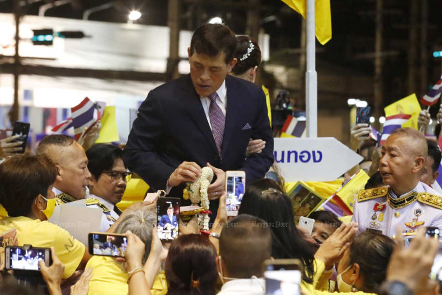 His Majesty the King is greeted by well-wishers as he and the Queen officially open the new Blue Line extension at Sanam Chan on Nov 14. Gen Apirat Kongsompong is on the right,  in white uniform. (Photo: Apichit Jinakul)