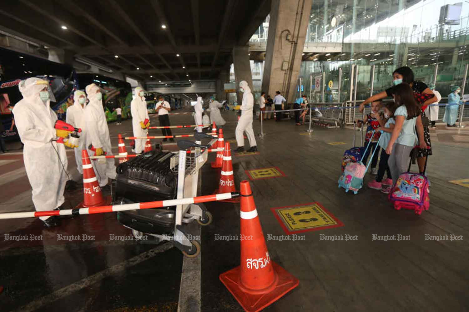 A family arrives at Suvarnabhumi airport in Samut Prakan province and heads for quarantine. (Photo: Varuth Hirunyatheb)