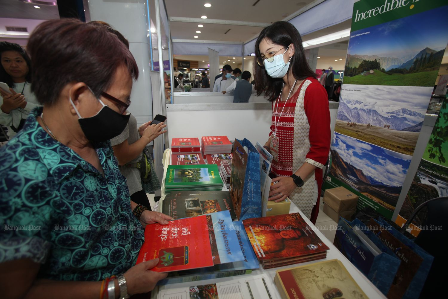 People wearing protective masks visit a booth at the Bay of Bengal cultural exhibition at MBK Center in Bangkok on Friday. (Photo by Nutthawat Wichieanbut)