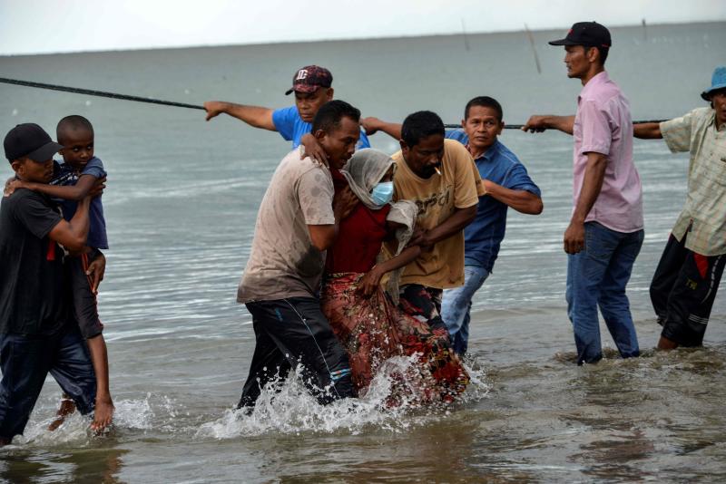 FILE PHOTO: Acehnesse fishermen help evacuate a Rohingya child and a woman from Myanmar onto the shorelines of Lancok village in Indonesia's North Aceh Regency on June 25, 2020. (AFP) FILE PHOTO: Acehnesse fishermen help evacuate a Rohingya child and a woman from Myanmar onto the shorelines of Lancok village in Indonesia's North Aceh Regency on June 25, 2020. (AFP)