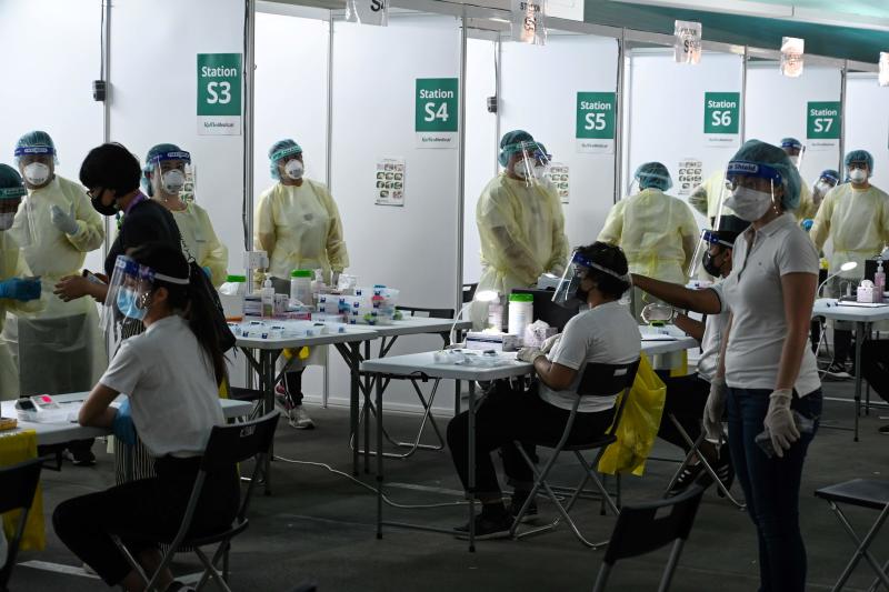 Health personnel prepare antigen rapid test for Covid-19 coronavirus for passengers during embarkation procedures on a World Dream cruise ship for Health personnel prepare antigen rapid test for Covid-19 coronavirus for passengers during embarkation procedures on a World Dream cruise ship for