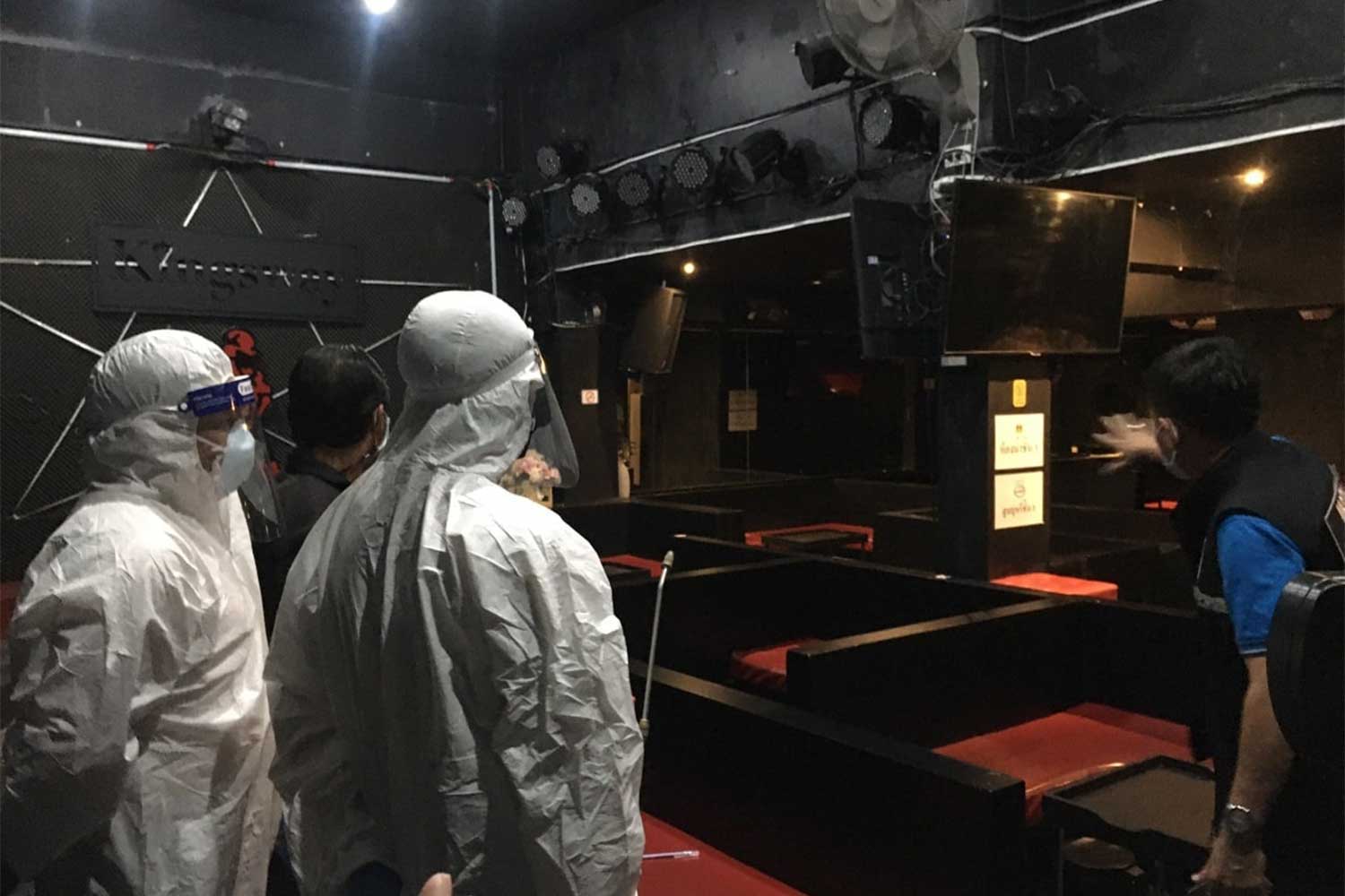 Workers in protective gear spray disinfectant inside a karaoke bar in the Santitham area of tambon Chang Phuek in Muang district of Chiang Mai on Saturday. It was one of the spots visited by a local Covid-infected woman on the night of Nov 24. (Photo from Tourist Police Division 2 Facebook page)