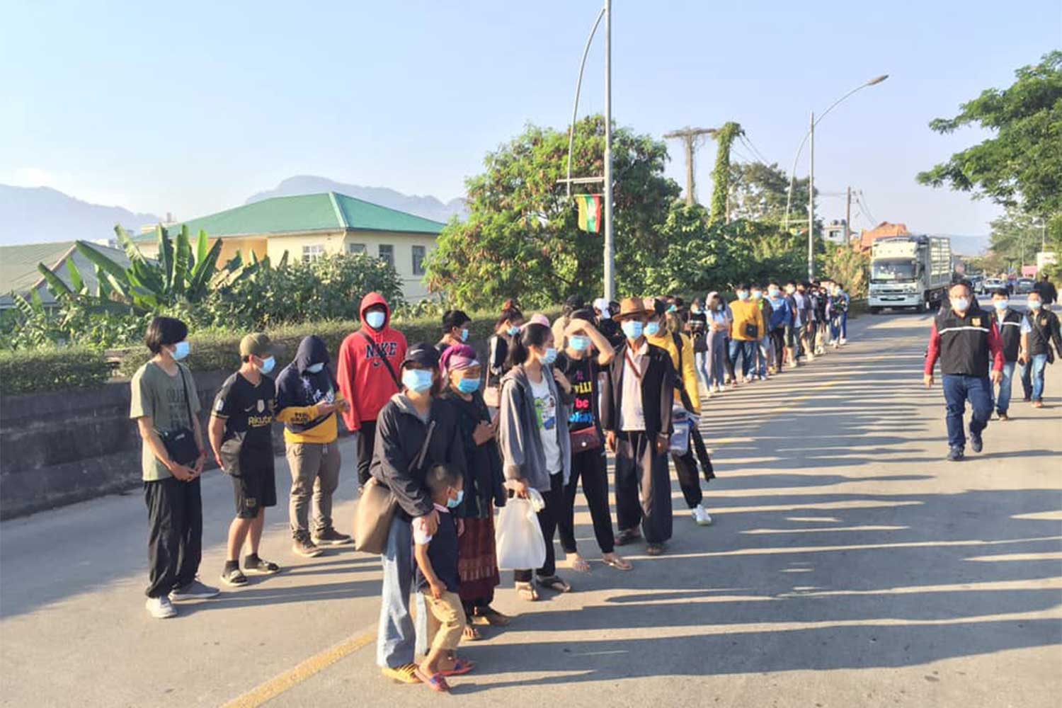 Some of the more than 100 Thais, including children, gather near the checkpoint on the second Thai-Myanmar Friendship Bridge on Friday afternoon to enter the country. (Photo taken from Mae Sai district office Facebook page)