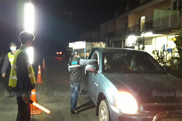 Officials check temperatures of drivers on Sunday night as they step up health measures in Mae Sai district of Chiang Rai. (Mae Sai district office photo)