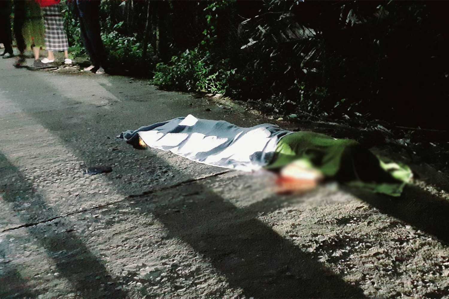The body of the slain 26-year-old man lies on the road in tambon Torbon of Sai Buri district, Pattani, on Thursday morning. (Photo: Abdullah Benjakat)