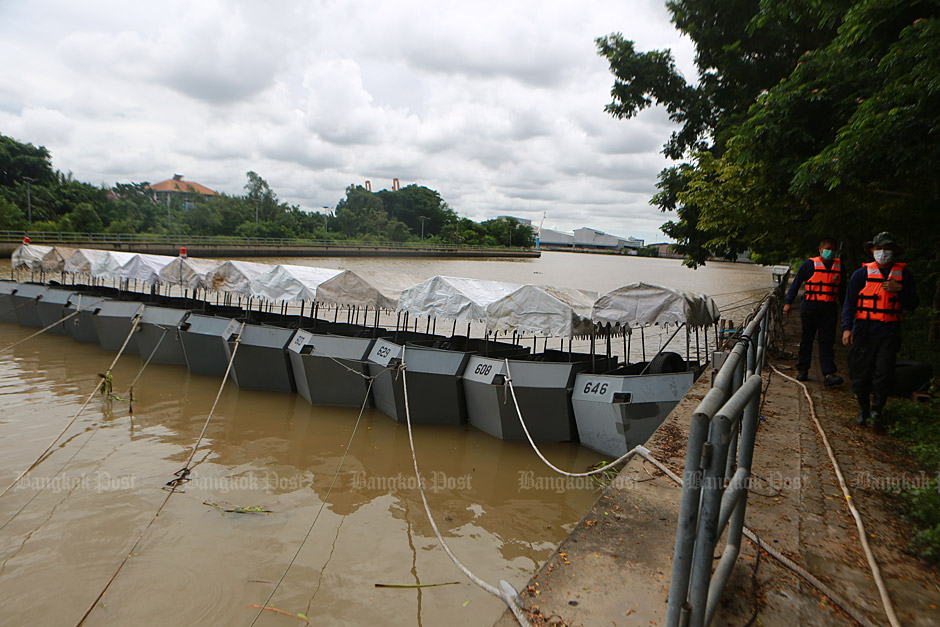 'Water pusher' boats, near a floodgate in Samut Prakan, used to accelerate the drainage of excess water from the Chao Phraya River. (Photo by Somchai Poomlard)