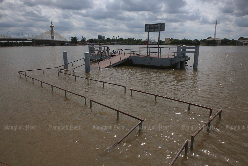 A walkway connecting the Tha Kwan boat landing is submerged by the rising Chao Phraya River in Nonthaburi. (Photo by Pattarapong Chatpattarasill)