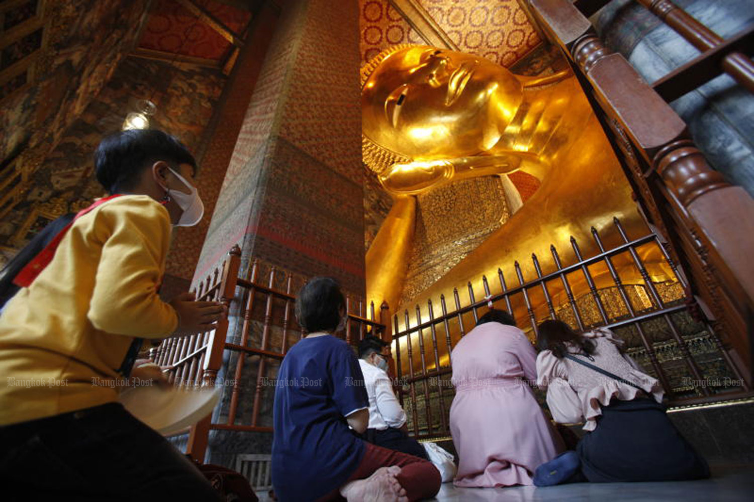 People pay homage to the giant reclining Buddha statue at Wat Phra Chetuphon Wimon Mangkhalaram (Wat Pho) in Bangkok on Friday. (Photo by Nutthawat Wicheanbut) People pay homage to the giant reclining Buddha statue at Wat Phra Chetuphon Wimon Mangkhalaram (Wat Pho) in Bangkok on Friday. (Photo by Nutthawat Wicheanbut)