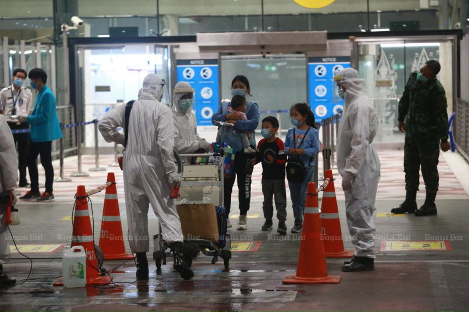 Health officials check the body temperature of visitors from China arriving at Suvarnabhumi airport from Shanghai on Oct 21, 2020. (Photo by Somchai Poomlard)