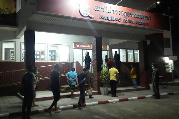 Arrested gamblers arrive at a police station in Nakhon Sawan on Monday night after police raided a house in Banphot Phisai district. They had all come from neighbouring Pichit to try their luck. (Photo: Chalit Poomruang)