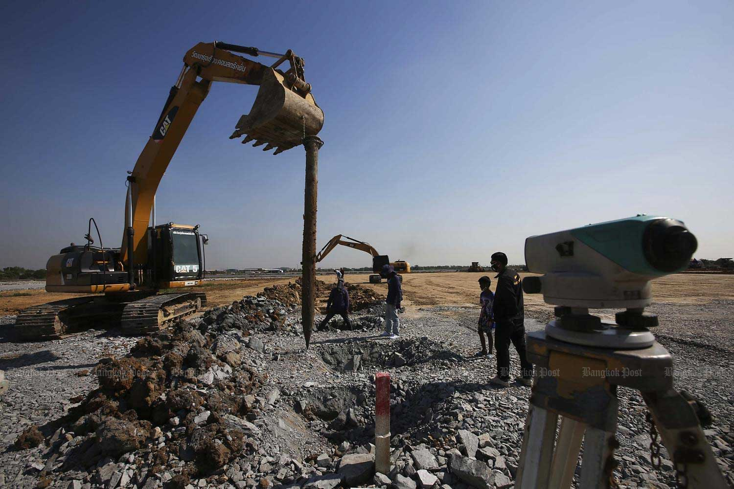 People operate heavy machinery to clear and drill during the construction of a field hospital at the 100-rai Watthana Factory project site in Samut Sakhon, an epicentre of the new wave of Covid-19 infections. The field hospital, costing five billion baht to build, will be equipped with 1,000 beds for Covid-19 patients.