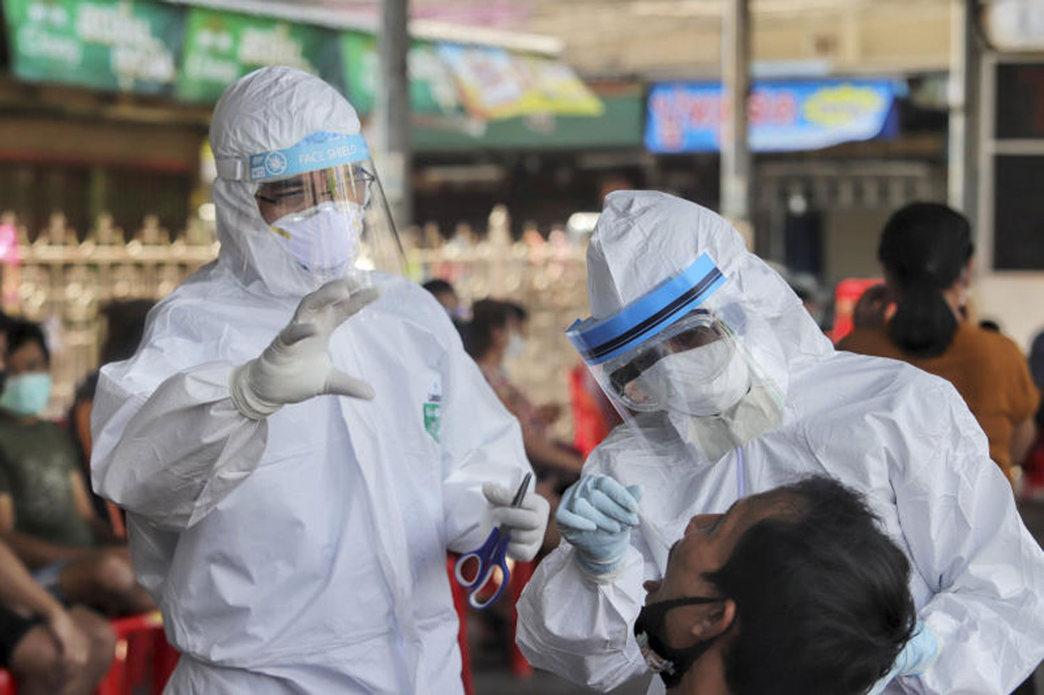 Health workers test a migrant worker at Talad Pornpat or Rangsit Market in Pathum Thani on Friday. A total of 200 migrant workers at the market took the tests. (Photo by Pongpat Wongyala)