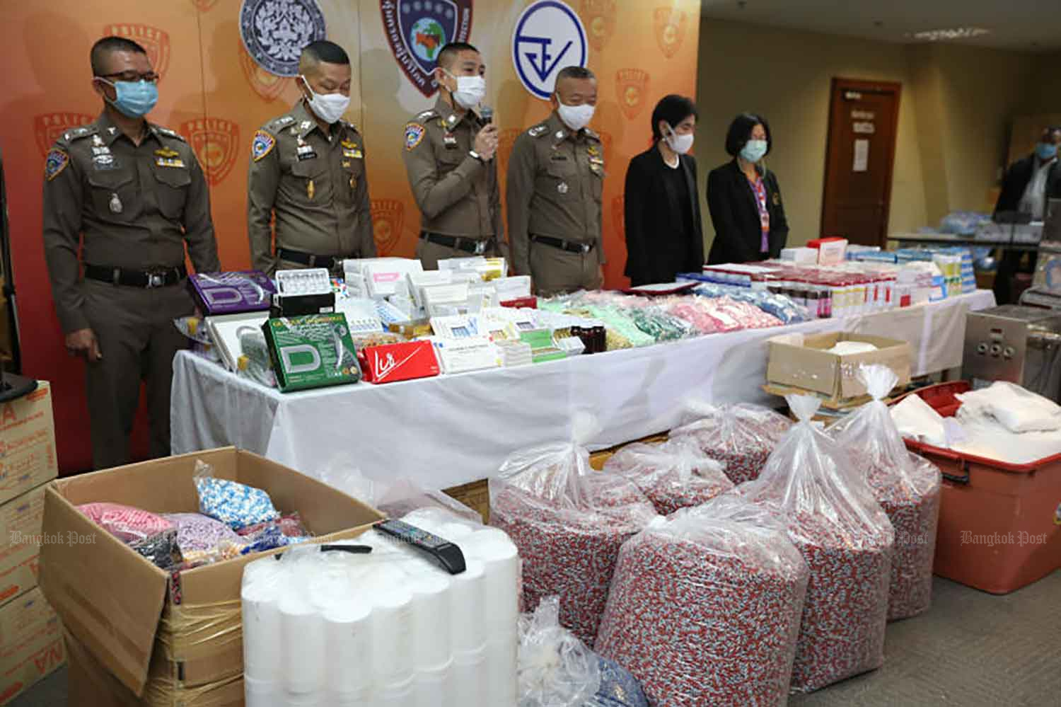 Consumer protection police and Food and Drug Administration officials show the large quantity of illegal medicines, beauty products, food supplements and ingredients seized during the raid in Nakhon Pathom on Tuesday. (Photo: Varuth Hirunyatheb)