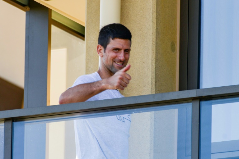 Under-fire: Novak Djokovic gestures from his hotel balcony in Adelaide, one of the locations where players are quarantined for two weeks ahead of the Australian Open in Melbourne Under-fire: Novak Djokovic gestures from his hotel balcony in Adelaide, one of the locations where players are quarantined for two weeks ahead of the Australian Open in Melbourne