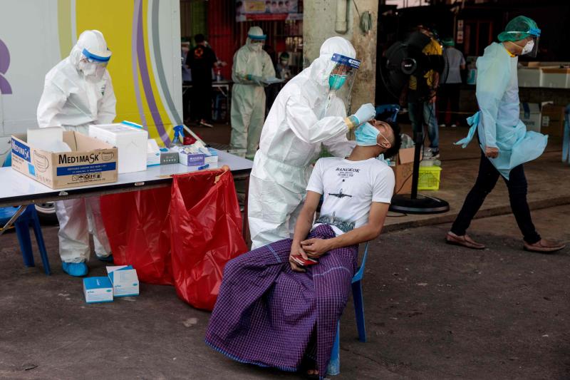 FILE PHOTO: Medical officials collect a nose swab sample to test for the Covid-19 coronavirus at a seafood market in Samut Sakhon, after some cases of local infections were detected and linked to a vendor at the market, Dec 19, 2020. (AFP)