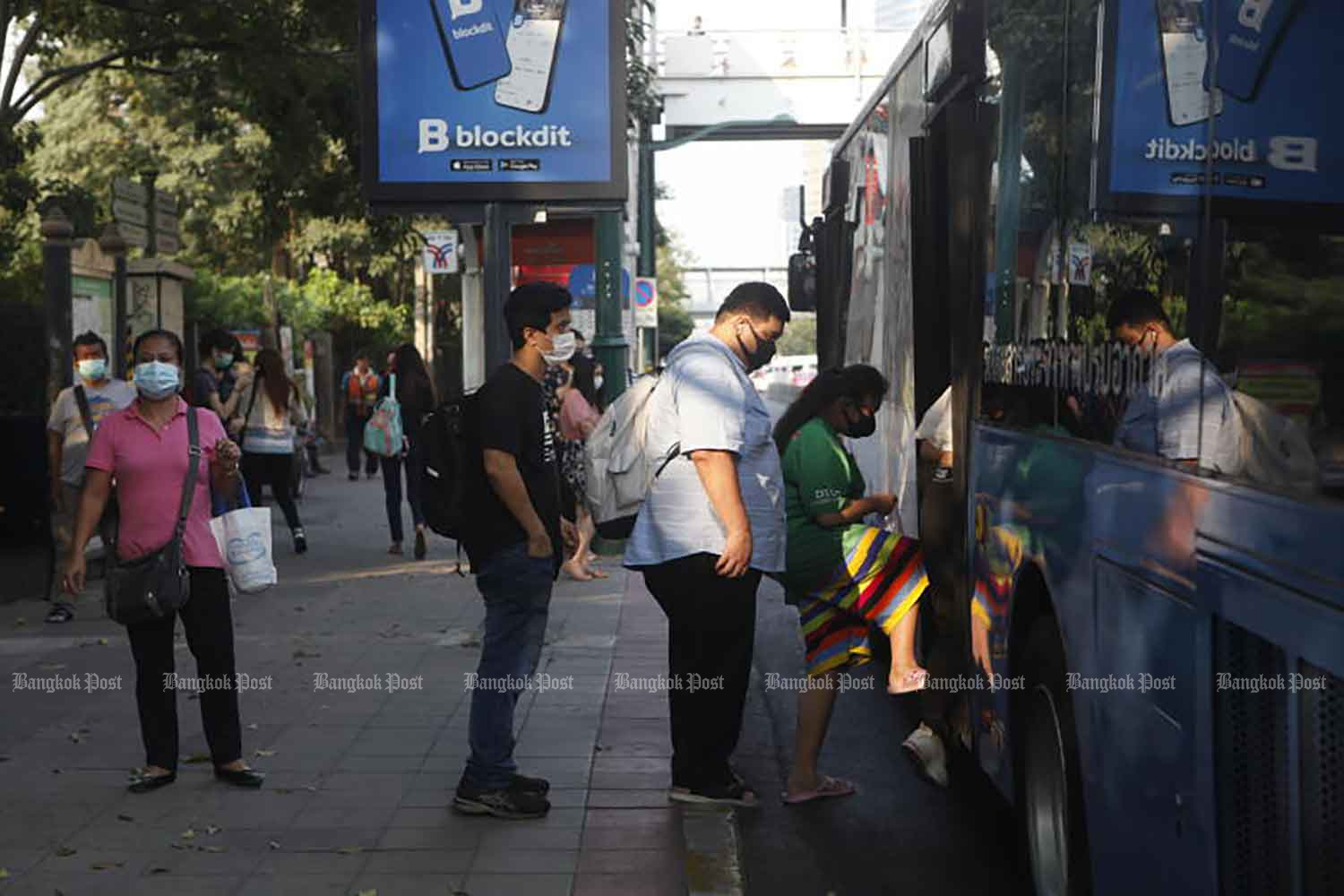 Commuters wearing face masks board a bus in Chatuchak district of Bangkok on Tuesday, when 819 new cases of Covid-19 disease were detected. (Photo: Nutthawat Wicheanbut)