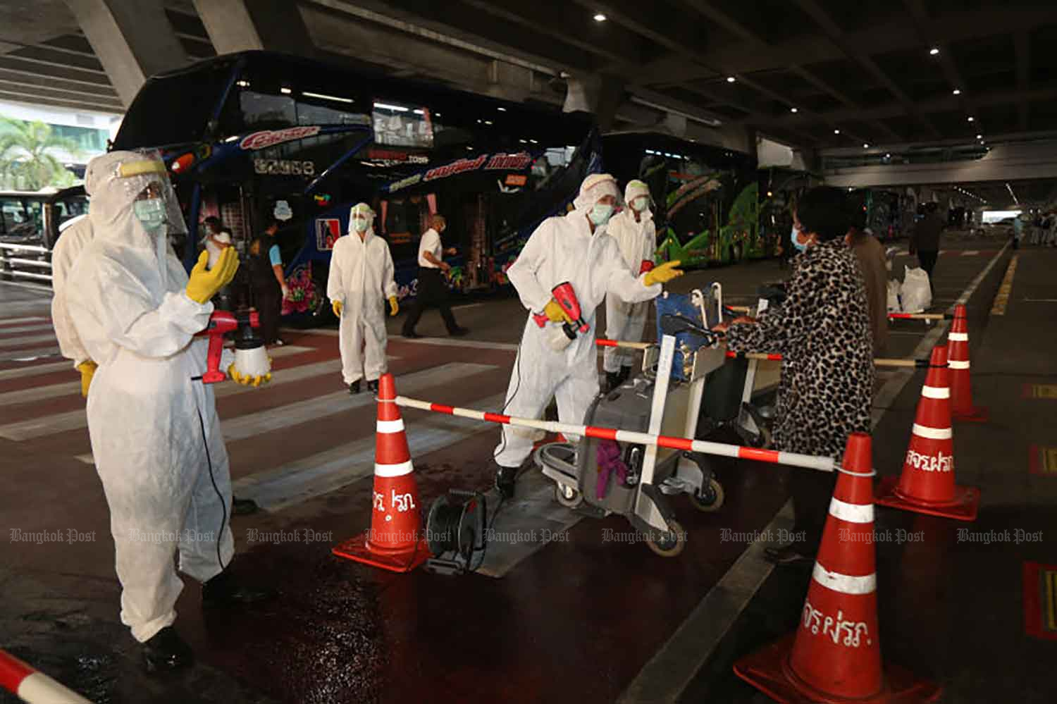 Disease control workers receive arrivals for quarantine at Suvarnabhumi airport in Samut Prakan province last October. (Photo by Arnun Chonmahatrakool)