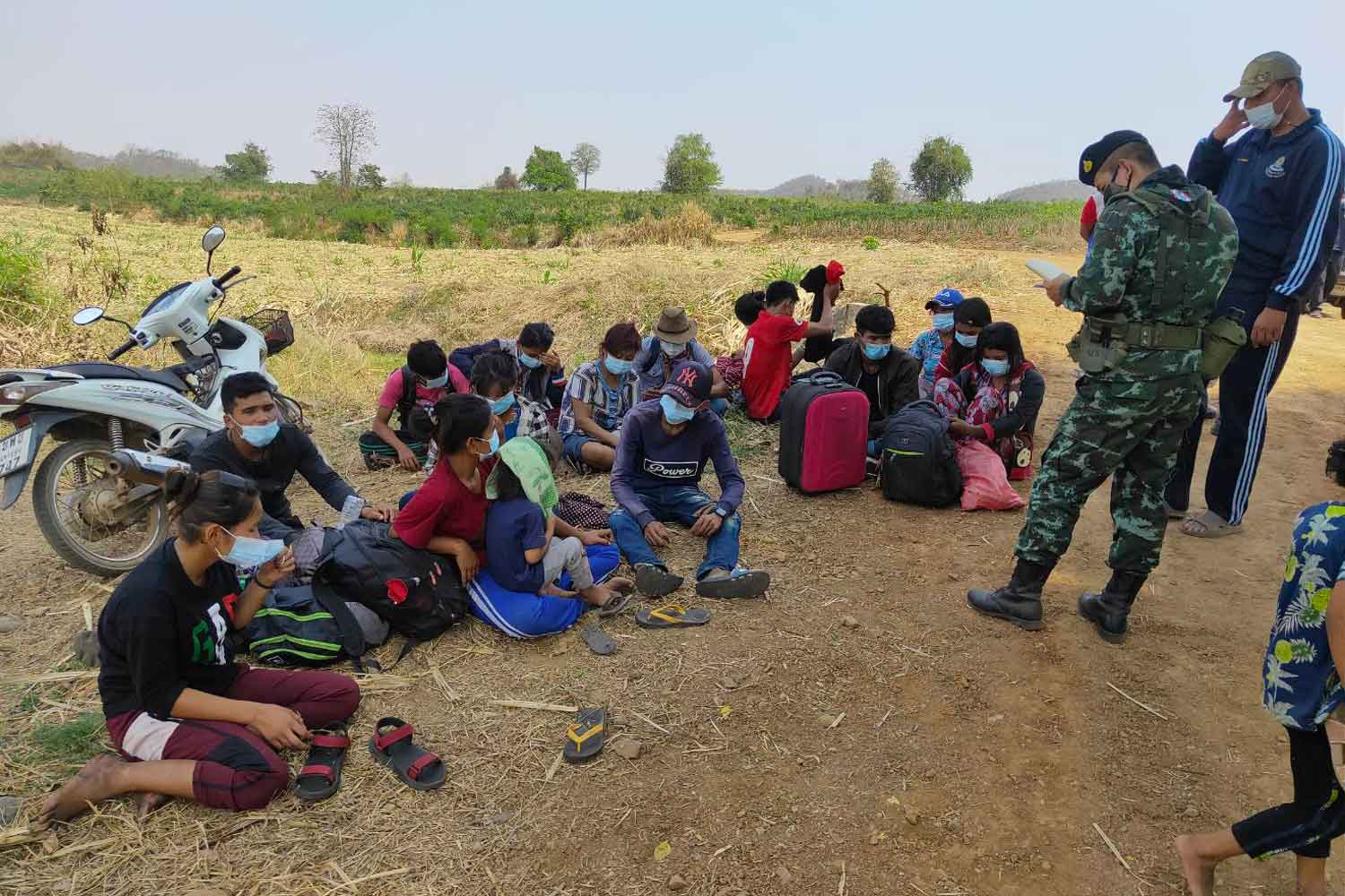 Soldiers question the 17 Myanmar workers arrested for illegal entry near a village in tambon Ban Kao in Muang district, Kanchanaburi, on Monday. (Photo: Piyarat Chongcharoen)