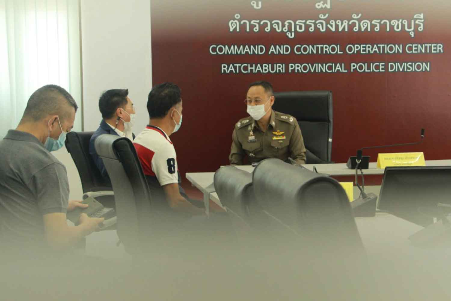 Wanchart Niamraksa, third from left, surrenders to the Ratchaburi police chief on Tuesday. He is the prime suspect in the shooting at a funeral in Photharam district on Monday night which took the life of a mayoral candidate running against his wife, and left six other people wounded. (Photo: Saichol Srinuanchan)