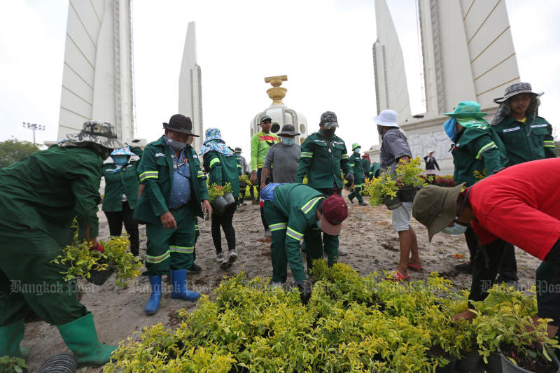 Bangkok Metropolitan Administration officials examine plants used to decorate Democracy Monument, which were removed by protesters on Feb 13, 2021. (Photo by Varuth Hirunyatheb)