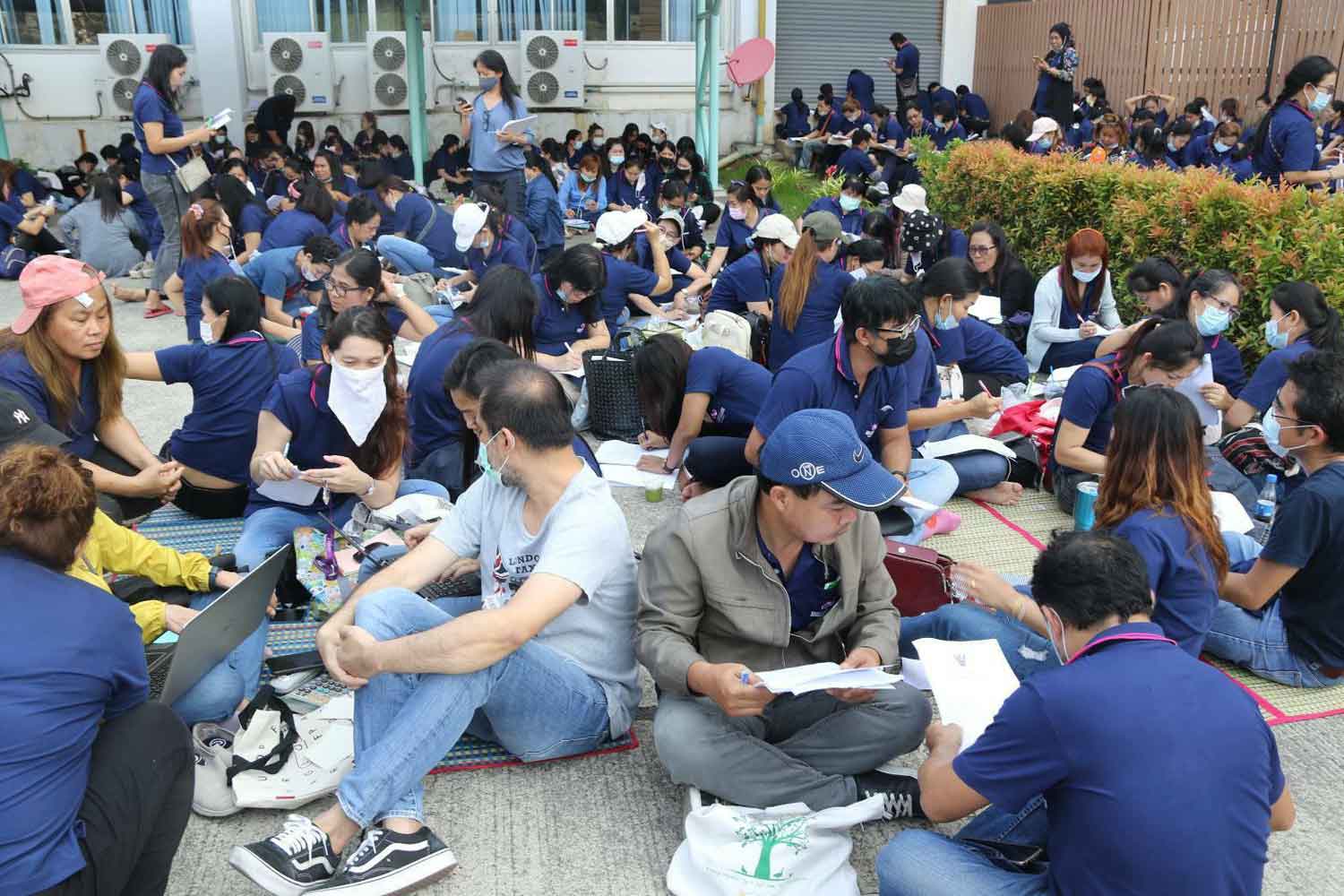 Laid-off workers from the Brilliant Alliance Thai Global lingerie factory gather outside the factory in Samut Prakan's Bang Sao Thong district on Thursday, after the company announced its sudden closure on Wednesday night. (Photo supplied)