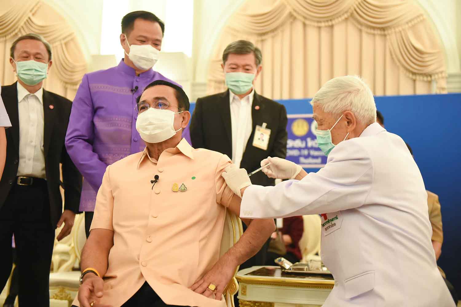 Prime Minister Prayut Chan-o-cha, left, is given the AstraZeneca Covid-19 vaccine by Prof Dr Yong Poovorawan, head of the Centre of Excellence in Clinical Virology, at Government House in Bangkok on Tuesday morning. (Photo from the Covid-19 Information Centre)