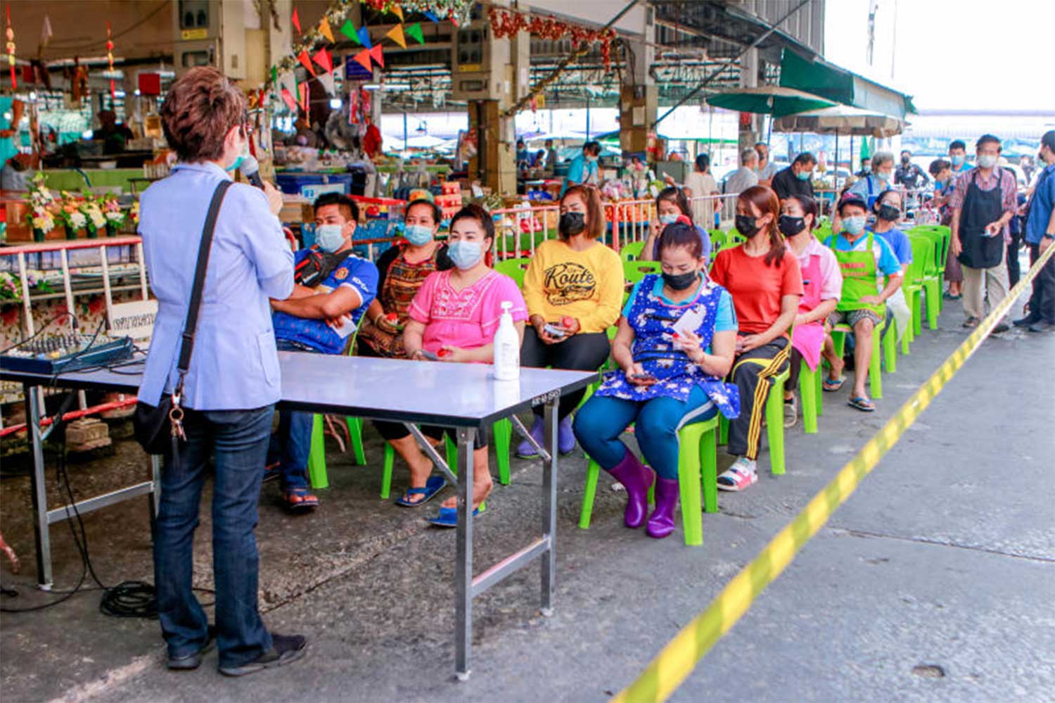 Vendors at Muang municipal market in Nakhon Sawan province wait their turn as health officials collect nasal samples for Covid-19 testing, at the market on Friday. (Photo: Chalit Pumruang)