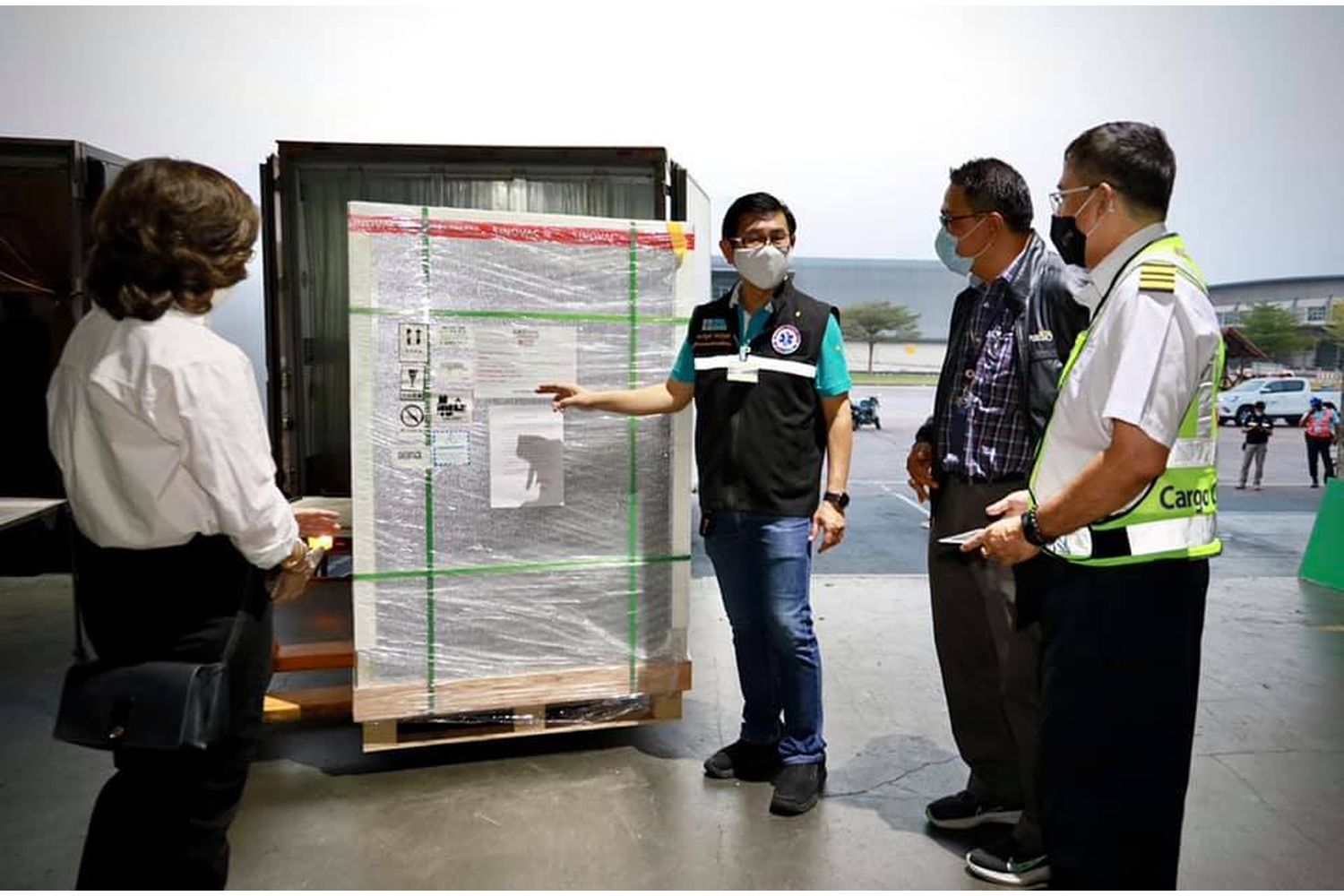 Officials inspect a crate containing some of the 800,000 shots of CoronaVac that arrived at Suvarnabhumi Airport on Saturday. (Photo from อนุทิน ชาญวีรกูล Facebook)