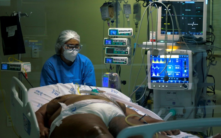A health worker cares for a Covid-19 patient in the intensive care unit of Emilio Ribas Hospital in Sao Paulo, Brazil, on March 17, 2021 A health worker cares for a Covid-19 patient in the intensive care unit of Emilio Ribas Hospital in Sao Paulo, Brazil, on March 17, 2021