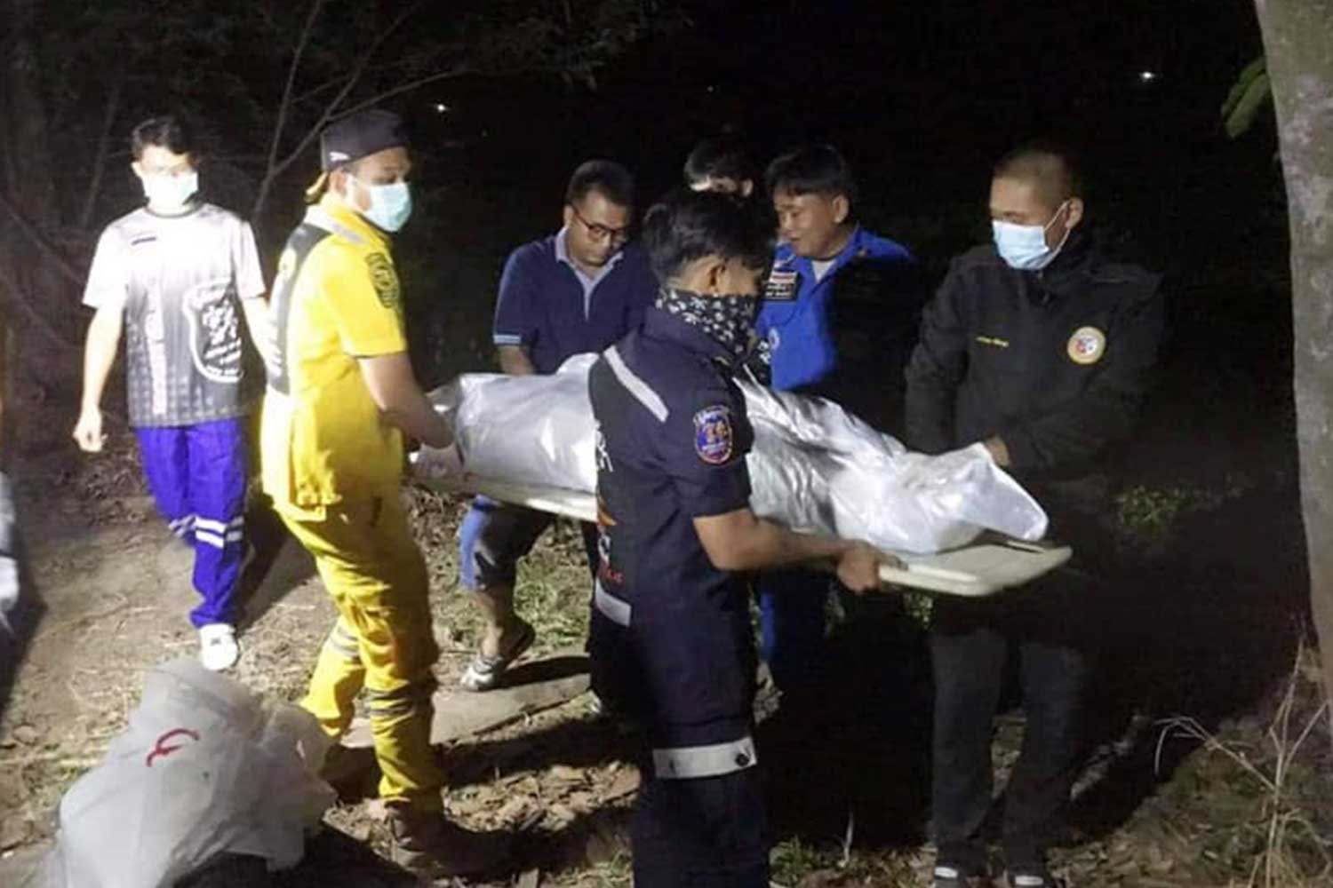 Rescue workers take the wrapped body of the 29-year-old woman from the public pond behind Bueng Hai village in Kamalasai district, Kalasin, on Tuesday night. Her husband was arrested for murder. (Photo: Kudwa Phrathat Yakhu rescue unit Facebook page)