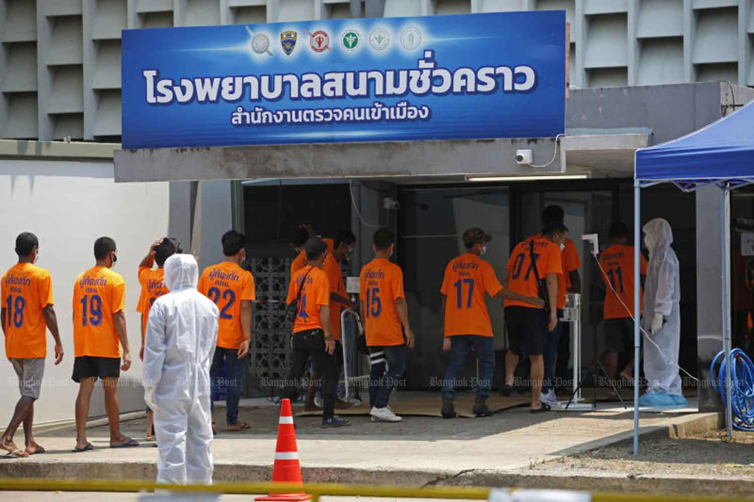 Health workers move 100 Covid-19 infected undocumented migrants from the immigration detention centre in Bang Khen district to the field hospital at the police-owned Boonyachinda Stadium in Laksi district on Wednesday, when the country logged 97 new cases. (Photo: Varuth Hirunyatheb)