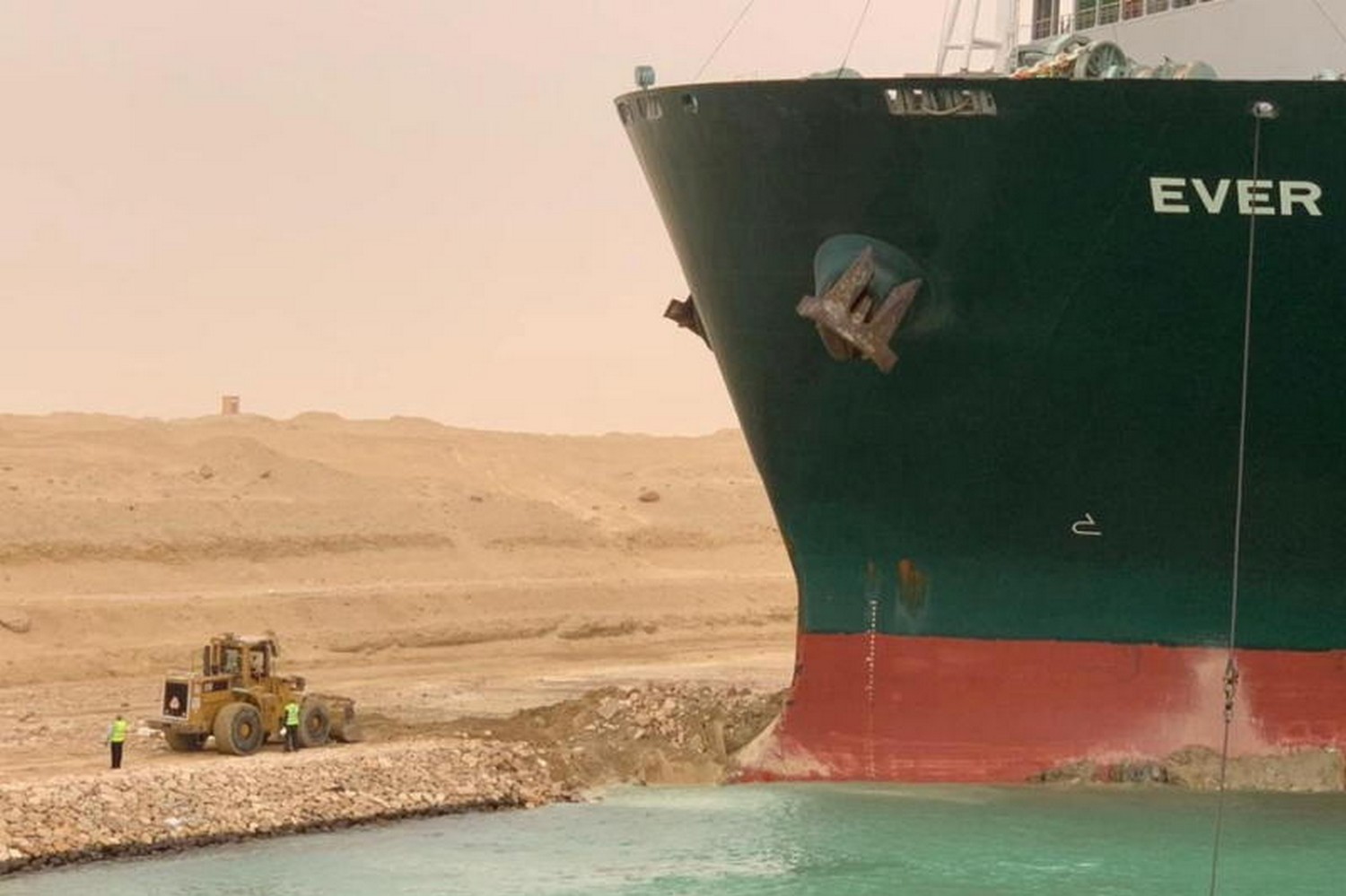 Workers are seen next to the bow of the huge container ship, lodged firmly in the bank of the Suez Canal. (Photo: Suez Canal Authority/Reuters) Workers are seen next to the bow of the huge container ship, lodged firmly in the bank of the Suez Canal. (Photo: Suez Canal Authority/Reuters)