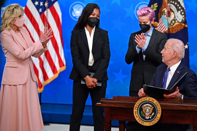 US President Joe Biden, with (L-R) his wife Jill Biden and US soccer stars Margaret Purce and Megan Rapinoe looking on, signed a proclamation on Equal Pay Day 2021 US President Joe Biden, with (L-R) his wife Jill Biden and US soccer stars Margaret Purce and Megan Rapinoe looking on, signed a proclamation on Equal Pay Day 2021