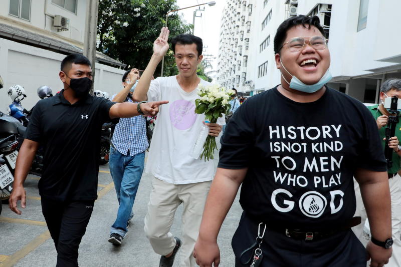 (Left to right:) Suranat Panprasert, 35, Ekachai Hongkangwan, 45, and Bunkueanun "Francis" Paothong, 21, appear at the attorney general's office after being indicted for attempted violence against the queen during a pro-democracy demonstration last year, when a royal motorcade encountered dozens of protesters, in Bangkok, on Wednesday.