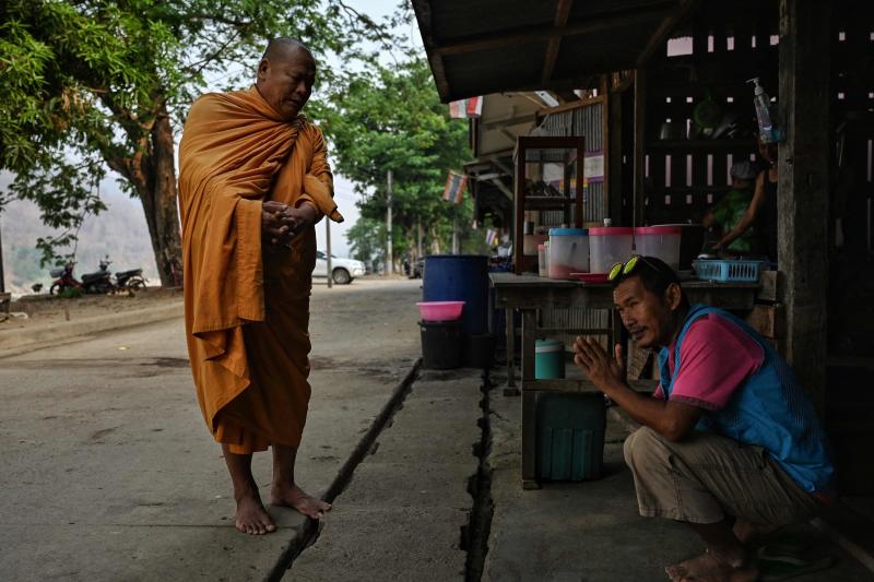 A Karen migrant living Thailand is blessed by a monk in Mae Sam Laep town on the Thai side of the Salween River in Mae Hong Son's Mae Sarieng district on Thursday. (AFP photo) A Karen migrant living Thailand is blessed by a monk in Mae Sam Laep town on the Thai side of the Salween River in Mae Hong Son's Mae Sarieng district on Thursday. (AFP photo)